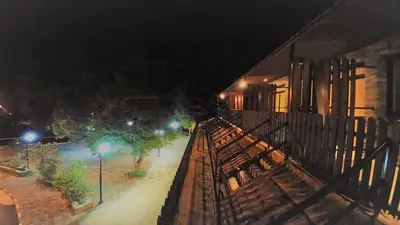 a train is parked next to a building at night at Perneia Rooms in Askas