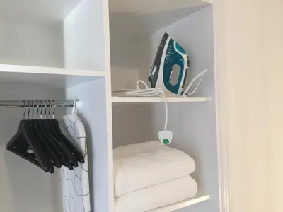 a white closet with towels and a shelf at Pasithea Holiday Apartments in Larnaka