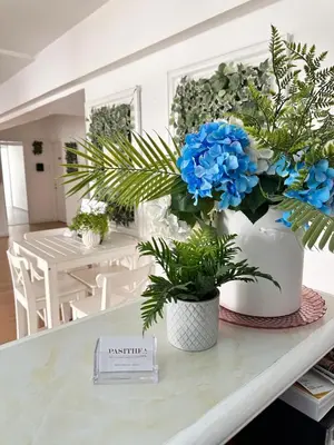 a table with two white vases with blue flowers on it at Pasithea Holiday Apartments in Larnaka