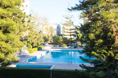 a swimming pool in a park with trees at Palm Beach Apartment 26 in Limassol