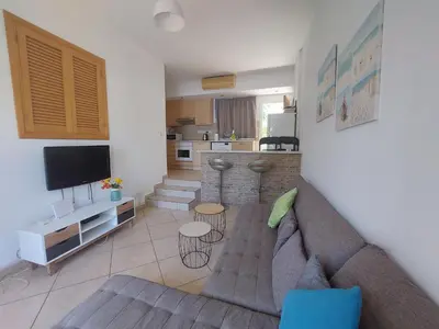 a living room with a couch and a kitchen at Palm Beach Apartment 26 in Limassol