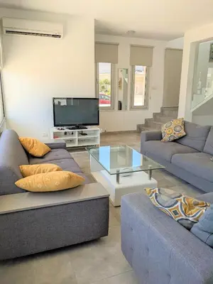 a living room with two couches and a tv at T&E Villa in Larnaka