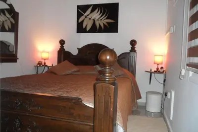 a bedroom with a wooden bed with two lamps at Apartment Ground Floor, FREE INTERNET in Ayia Napa