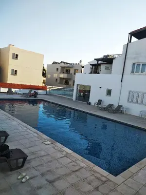 a swimming pool in front of a building at Apartment Ground Floor, FREE INTERNET in Ayia Napa