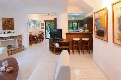 a living room with a couch and a tv and a kitchen at Green Bay Villa in Protaras