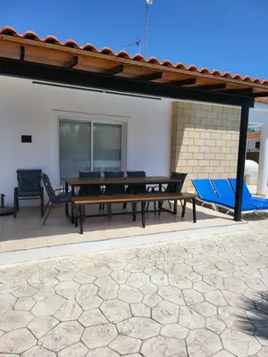 a patio with a ping pong table and chairs at Villa Gracia in Ayia Napa