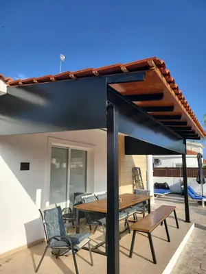 a pergola on a patio with a table and chairs at Villa Gracia in Ayia Napa