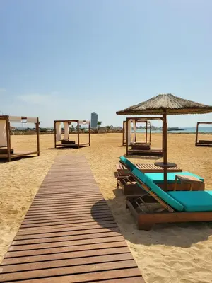 a beach with chairs and umbrellas on the sand at Villa Gracia in Ayia Napa