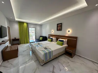 a bedroom with a large bed with a green curtain at Loutsiana Deluxe Apts in Ayia Napa