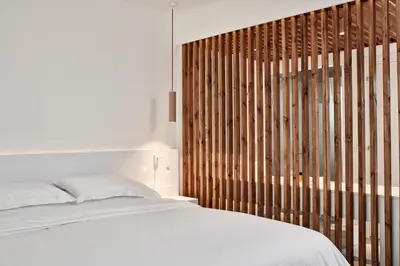 a bedroom with a white bed and a wooden wall at So Nice Beach Resort in Ayia Napa