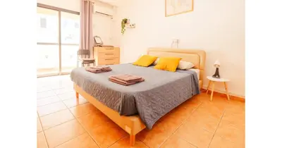 a bedroom with a bed with yellow pillows on it at Urban Stays in Ayia Napa