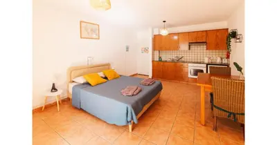 a bedroom with a bed and a kitchen at Urban Stays in Ayia Napa