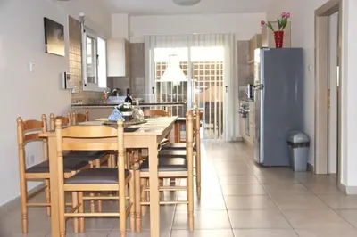a kitchen with a table and chairs and a refrigerator at Villa Agnes in Ayia Napa