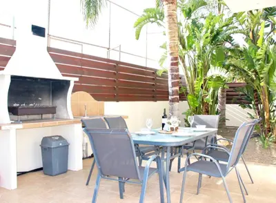 a table and chairs on a patio with palm trees at Villa Agnes in Ayia Napa