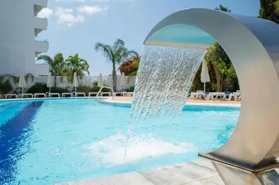 a water fountain in the middle of a swimming pool at Gaia Sun N Blue Hotel in Ayia Napa