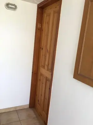 a wooden door in the corner of a room at Arsos Village Apartment in Arsos