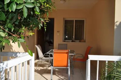 a dining room with orange chairs and a table at Sunset Garden Villa in Pervolia