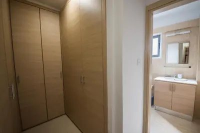 a bathroom with wooden cabinets and a sink at Skylight Megaron in Larnaka