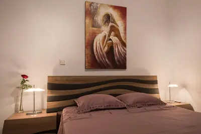 a bedroom with a bed with a painting on the wall at Skylight Megaron in Larnaka