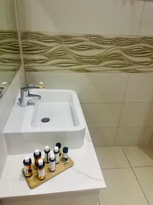 a bathroom sink with five bottles on a wooden tray at Riverside Suite in Kalopanayiotis