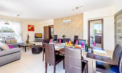 a dining room and living room with a table and chairs at Villa Marizan in Protaras