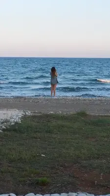 a woman standing on the beach looking at the ocean at Serenity Villa Mediterranean in Pervolia