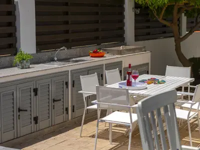a table and chairs with a sink and a kitchen at Passion Villa in Protaras