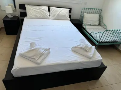 a bed with two towels on top of it at Apartment at luxurious Mythical Sands Resort in Paralimni