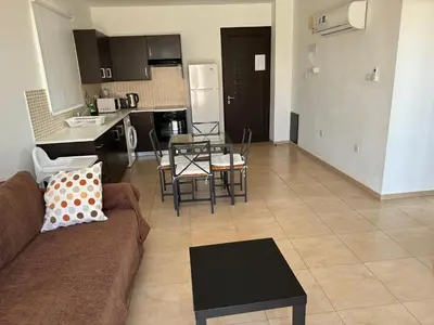 a living room and kitchen with a couch and a table at Apartment at luxurious Mythical Sands Resort in Paralimni