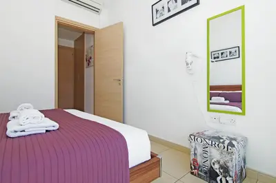 a bedroom with a bed with a purple blanket at Calypso - Coralli Beachfront Apartment in Protaras