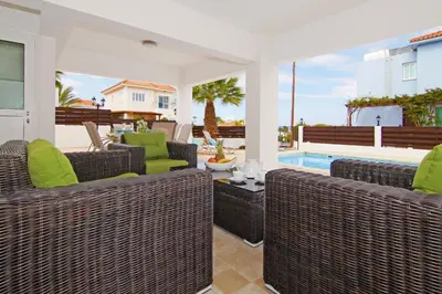 a patio with wicker chairs and a swimming pool at Villa Anette in Protaras