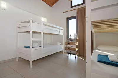 a bedroom with two bunk beds and a desk at Villa Ingrid in Ayia Napa