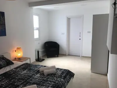 a bedroom with a bed and a chair and a lamp at Villa Nissi Beach 28 in Ayia Napa