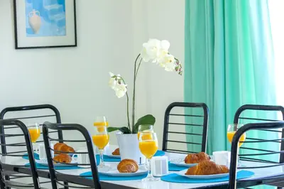 a table with plates of food and orange juice at Protaras Holiday Suite Annie in Protaras