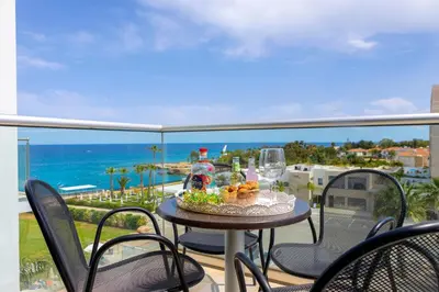 a table and chairs on a balcony with a view of the ocean at Coralli Spa By Fig tree Bay in Protaras