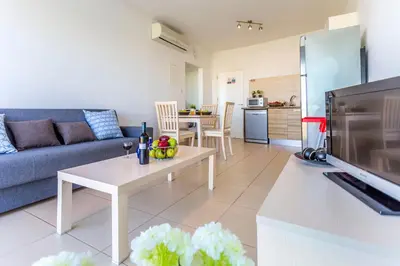 a living room with a couch and a table at Coralli Spa By Fig tree Bay in Protaras