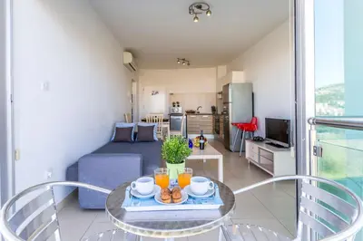 a living room with a table and a couch at Coralli Spa By Fig tree Bay in Protaras