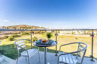a table and two chairs on a balcony with a view at Coralli Spa By Fig tree Bay in Protaras