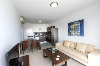 a living room with a couch and a table at Coralli Spa By Fig tree Bay in Protaras