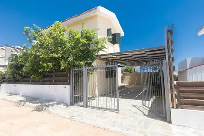 a gate in front of a house with a tree at Spetses Villa 5 in Protaras