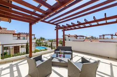 a patio with chairs and a table on a roof at Kymma Villa #16 in Ayia Napa