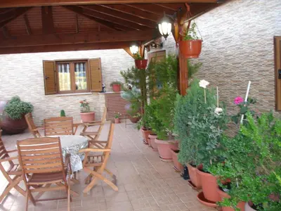 a patio with a table and chairs and potted plants at The Love Holiday House in Tris Elies