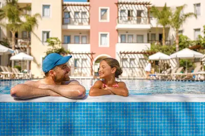 a man and a girl laying in a swimming pool at Louis Althea Beach in Protaras