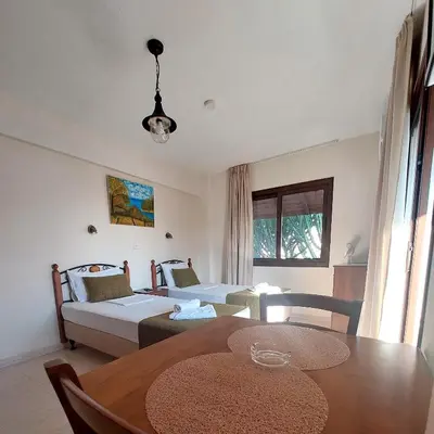 a living room with a table and a bed and a couch at Estia Vasilis Manoli in Ayia Napa