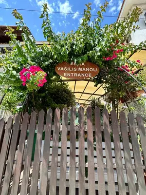 a fence in front of a building with flowers at Estia Vasilis Manoli in Ayia Napa