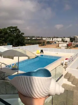 a person holding a bowl in front of a pool at Villa Spathele in Paralimni
