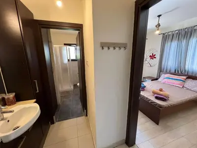 a bathroom with a bed and a sink and a mirror at George Apartments in Ayia Napa