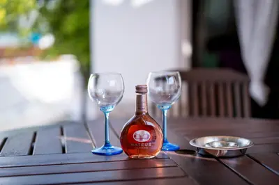 two wine glasses and a bottle on a wooden table at George Apartments in Ayia Napa