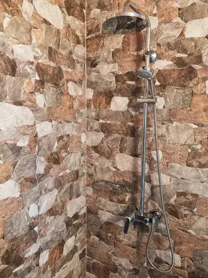 a shower in a bathroom with a stone wall at Vasiliou House Krimenos in Khandria