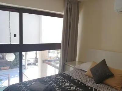 a bedroom with a bed and a large window at Galatex Beach Apartment in Limassol